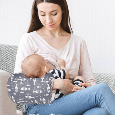 Bebe tetant coussin dallaitement Miemo sur le bras de maman au salon