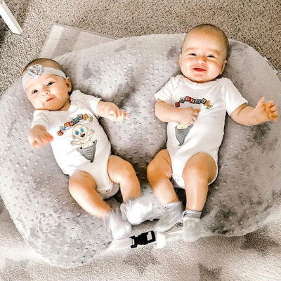 Des jumeaux souriant dans un coussin dallaitement Brefi