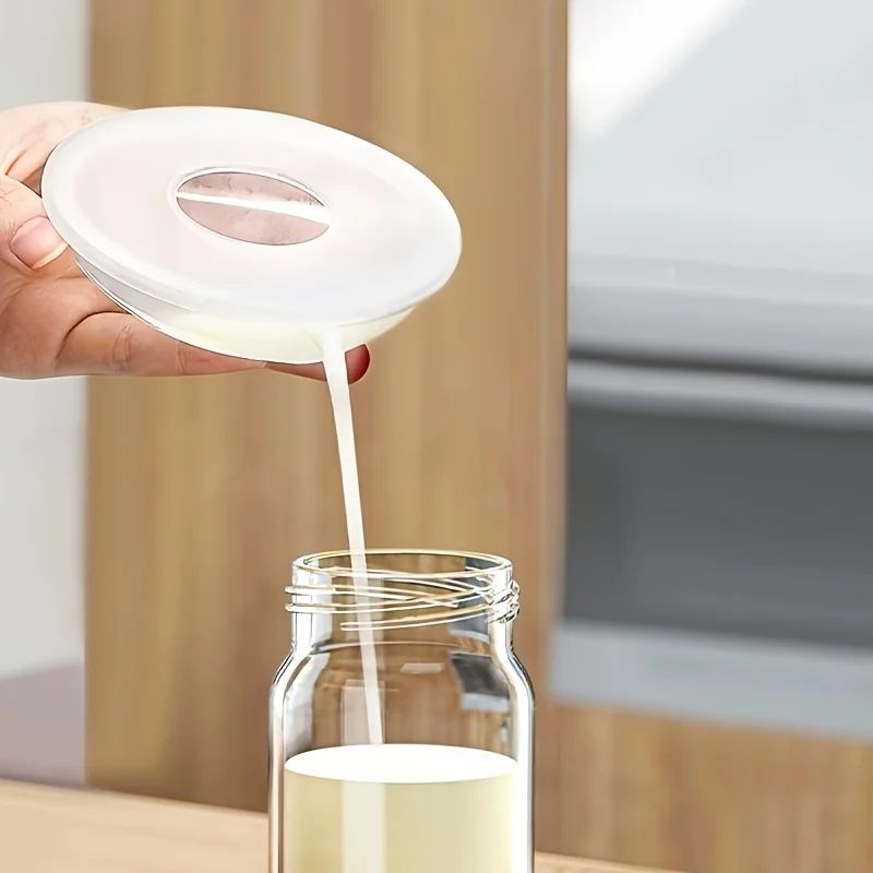 Maman verse le lait maternel recueilli de la coquille allaitement Shipresco dans un biberon 